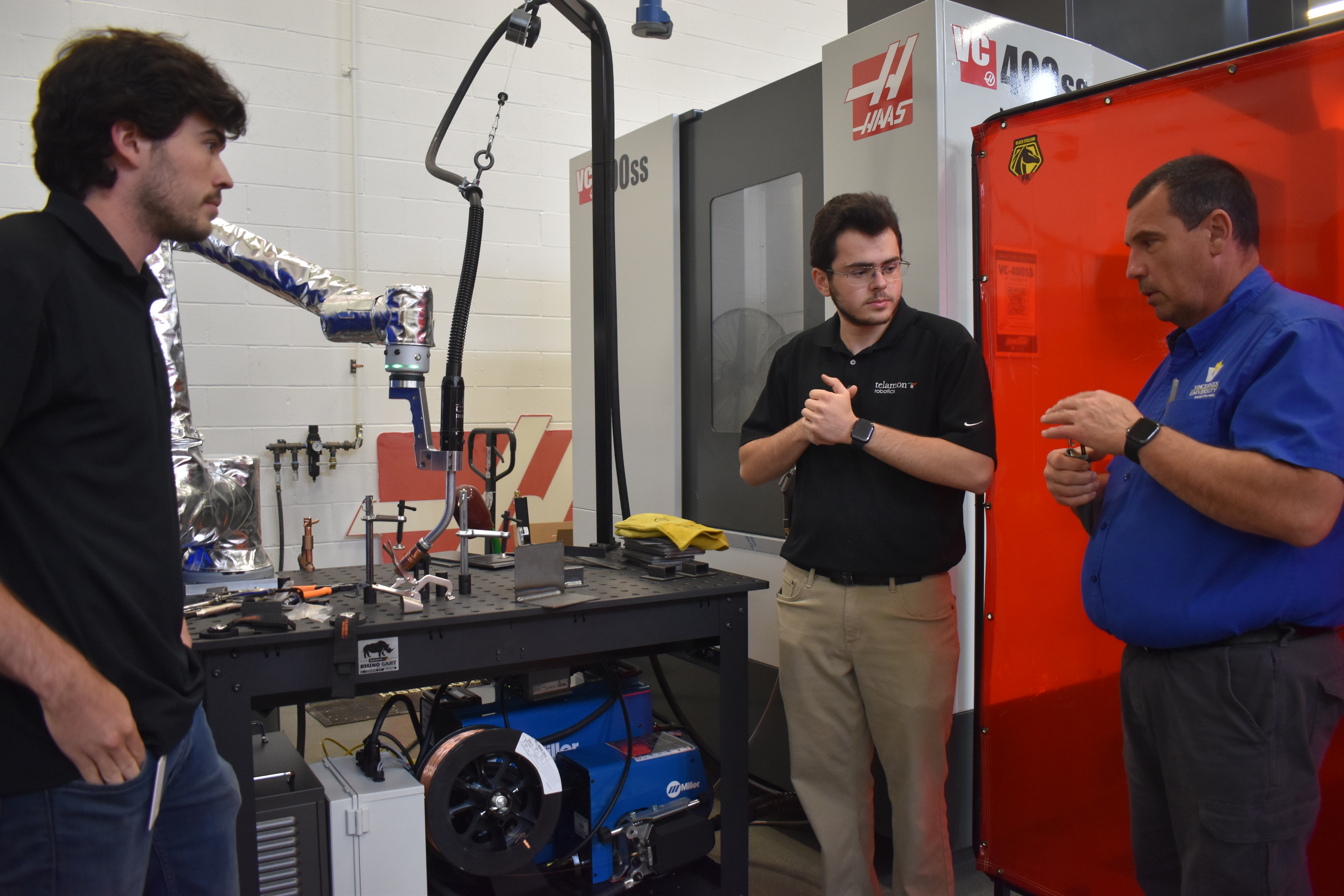 Telamon Robotics employees showcase a cobot that does welding
